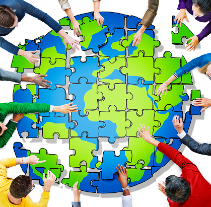 People with Jigsaw Puzzle Forming Globe